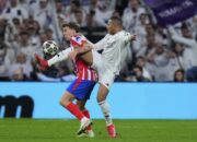 Gelandang Atletico Madrid Pablo Barrios berebut bola dengan striker Real Madrid Kylian Mbappe di laga leg pertama babak 16 besar Liga Champions, Rabu (5/3/2025). (c) AP Photo/Manu Fernandez