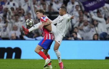 Gelandang Atletico Madrid Pablo Barrios berebut bola dengan striker Real Madrid Kylian Mbappe di laga leg pertama babak 16 besar Liga Champions, Rabu (5/3/2025). (c) AP Photo/Manu Fernandez